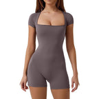 Woman wearing a gray bodysuit on a white background