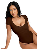 Woman wearing a brown bodysuit against a white background
