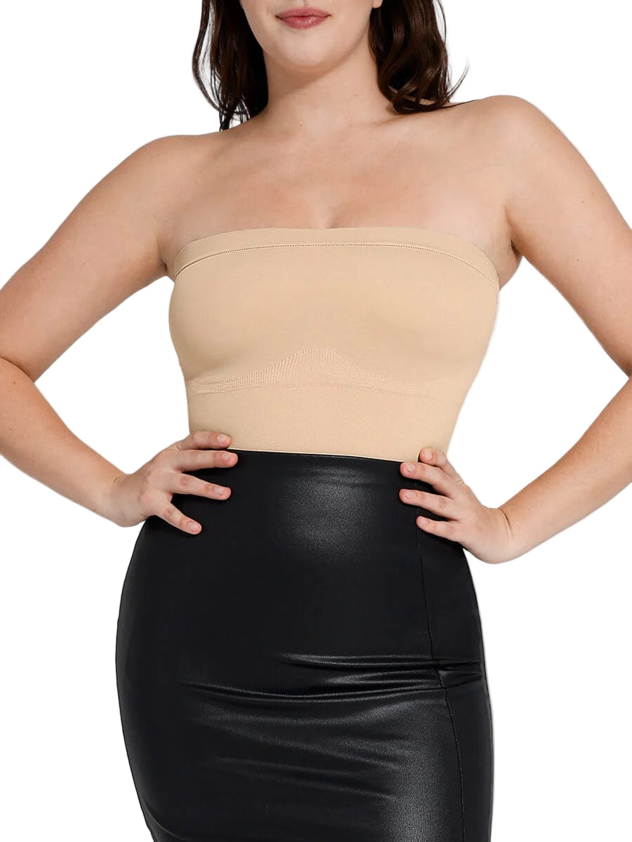 Woman wearing a beige strapless top and black leather skirt on a white background