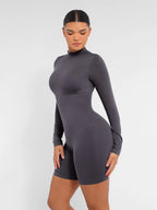 Person wearing a gray bodysuit against a white background