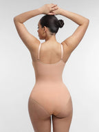 Woman wearing a beige bodysuit against a light gray background