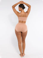 Woman wearing a beige shapewear outfit on a white background