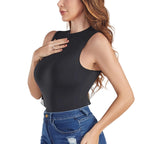 Woman wearing a black sleeveless top and blue jeans on a white background