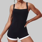 Person wearing a black tank top and white shorts on a plain background