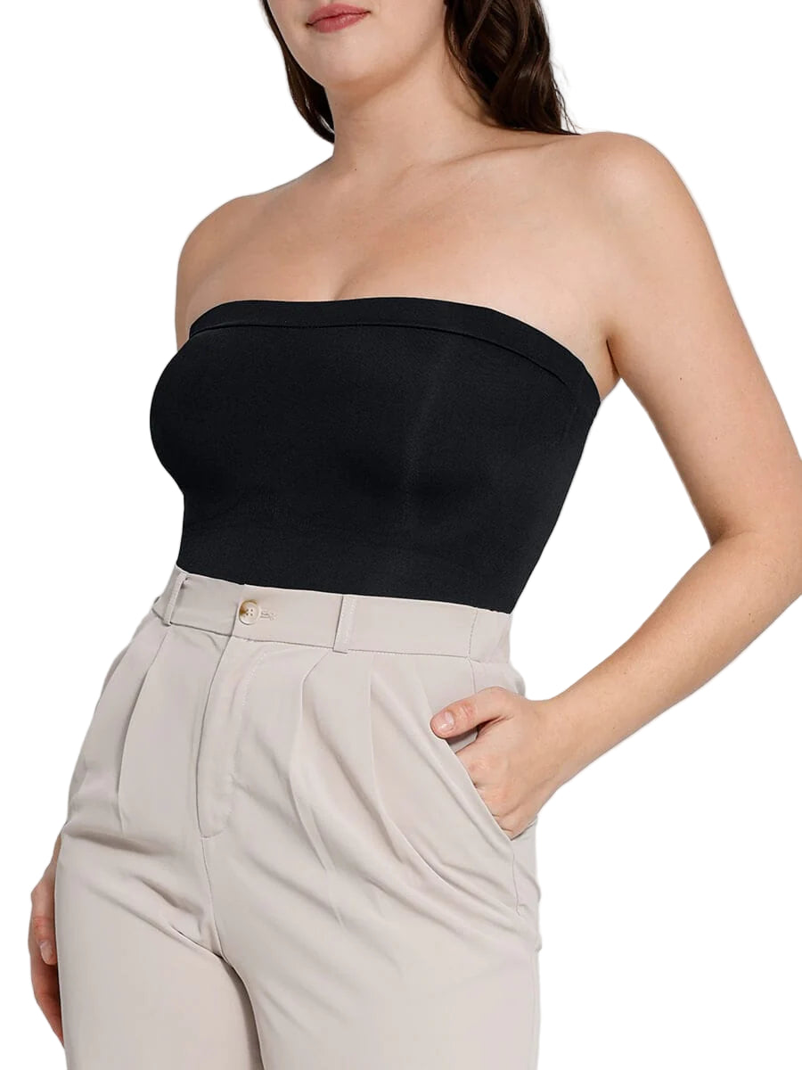 Woman wearing a black strapless top and beige pants against a white background