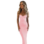 Woman wearing a pink dress against a textured wall.