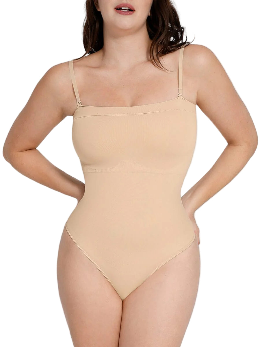 Woman wearing a beige bodysuit against a plain background
