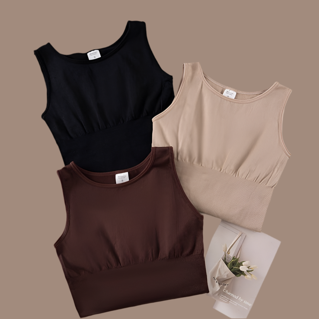 Three tank tops in black, brown, and beige on a brown background with a small card.