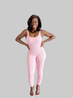 Woman wearing a pink jumpsuit against a gray background