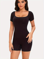 Woman wearing a black bodysuit against a white background