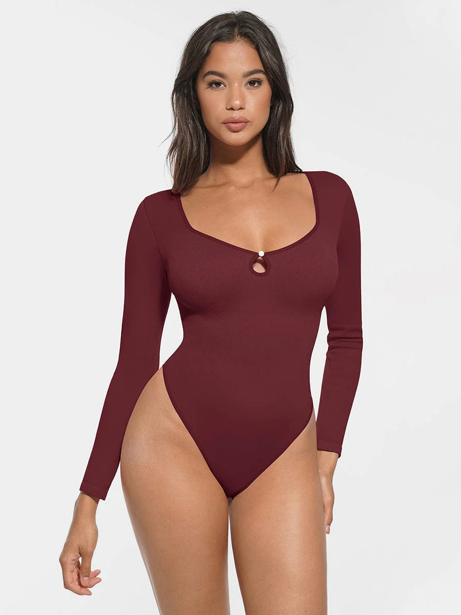 Woman wearing a burgundy long-sleeve swimsuit against a white background