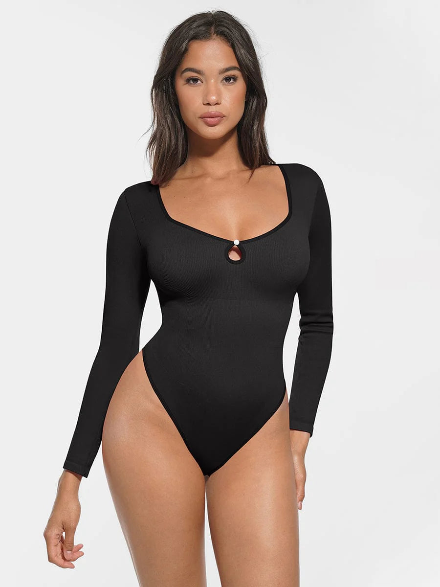 Woman wearing a black long-sleeve swimsuit against a white background