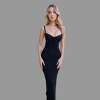 Woman in a black dress standing in an elegant architectural setting