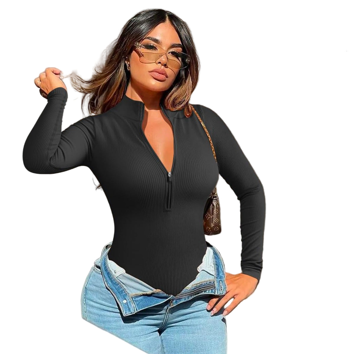 Woman wearing a black long-sleeve top and blue jeans with a neutral background