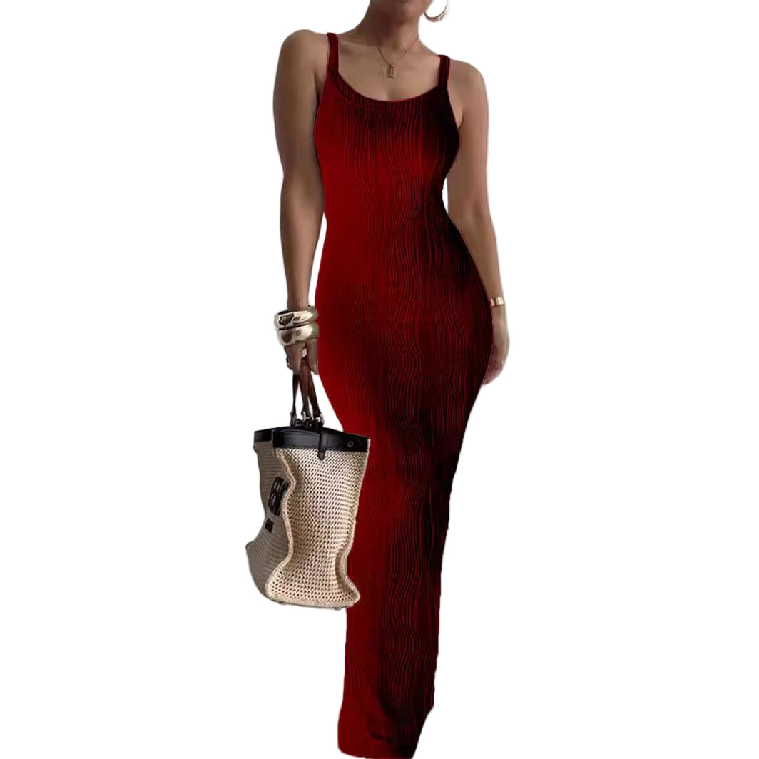 Person wearing a red dress holding a straw bag against a plain background
