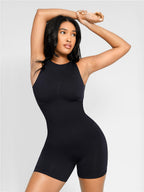 Woman wearing a black sleeveless dress against a light gray background