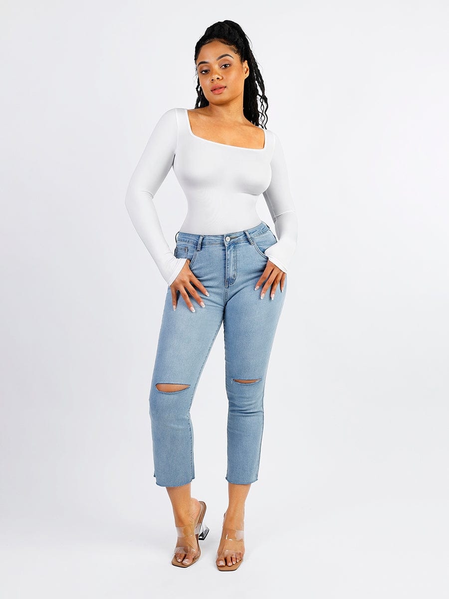 Person wearing a white long-sleeve bodysuit on a white background