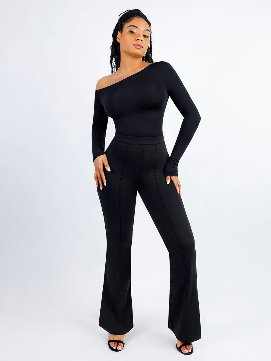 Woman wearing a black one-shoulder jumpsuit on a white background