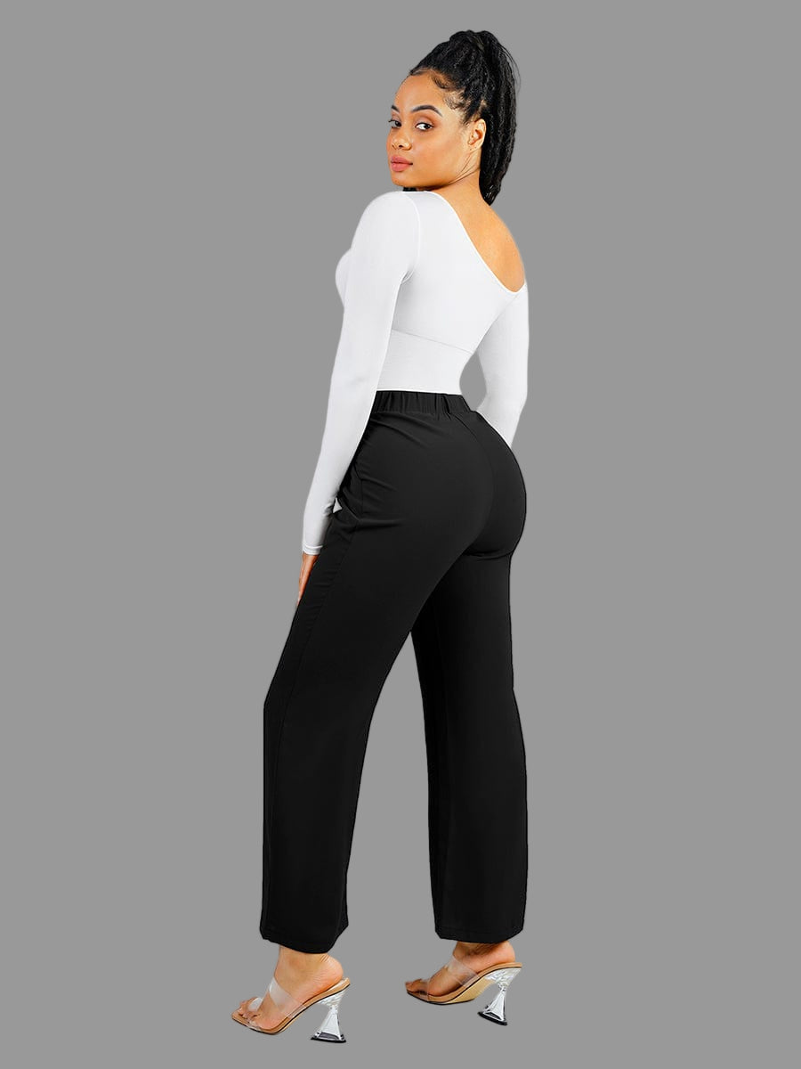 Person wearing a white long-sleeve top and black high-waisted pants on a white background