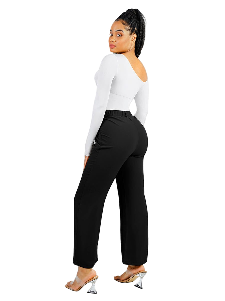 Person wearing a white long-sleeve top and black high-waisted pants on a white background